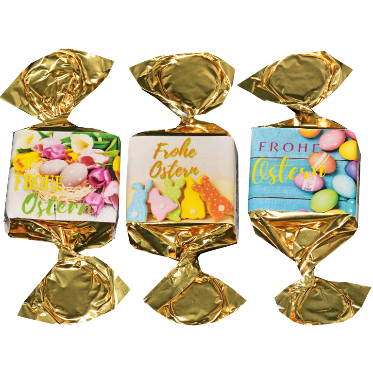 drei Nougat-Busserl in goldenes Papier gewickelt mit Etiketten nebeneinander abgebildet