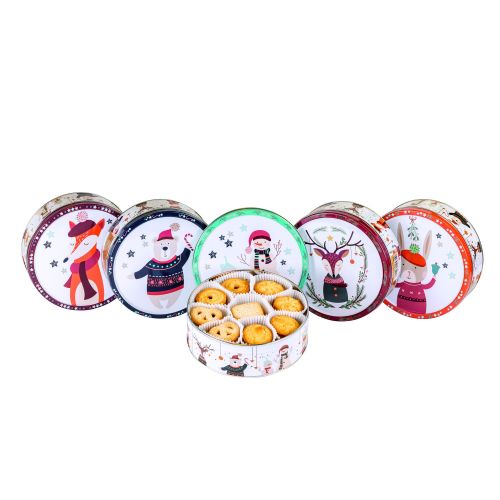 5 runde Dosen mit weihnachtlichem Motiv, davor eine geöffnete Dose mit Gebäck