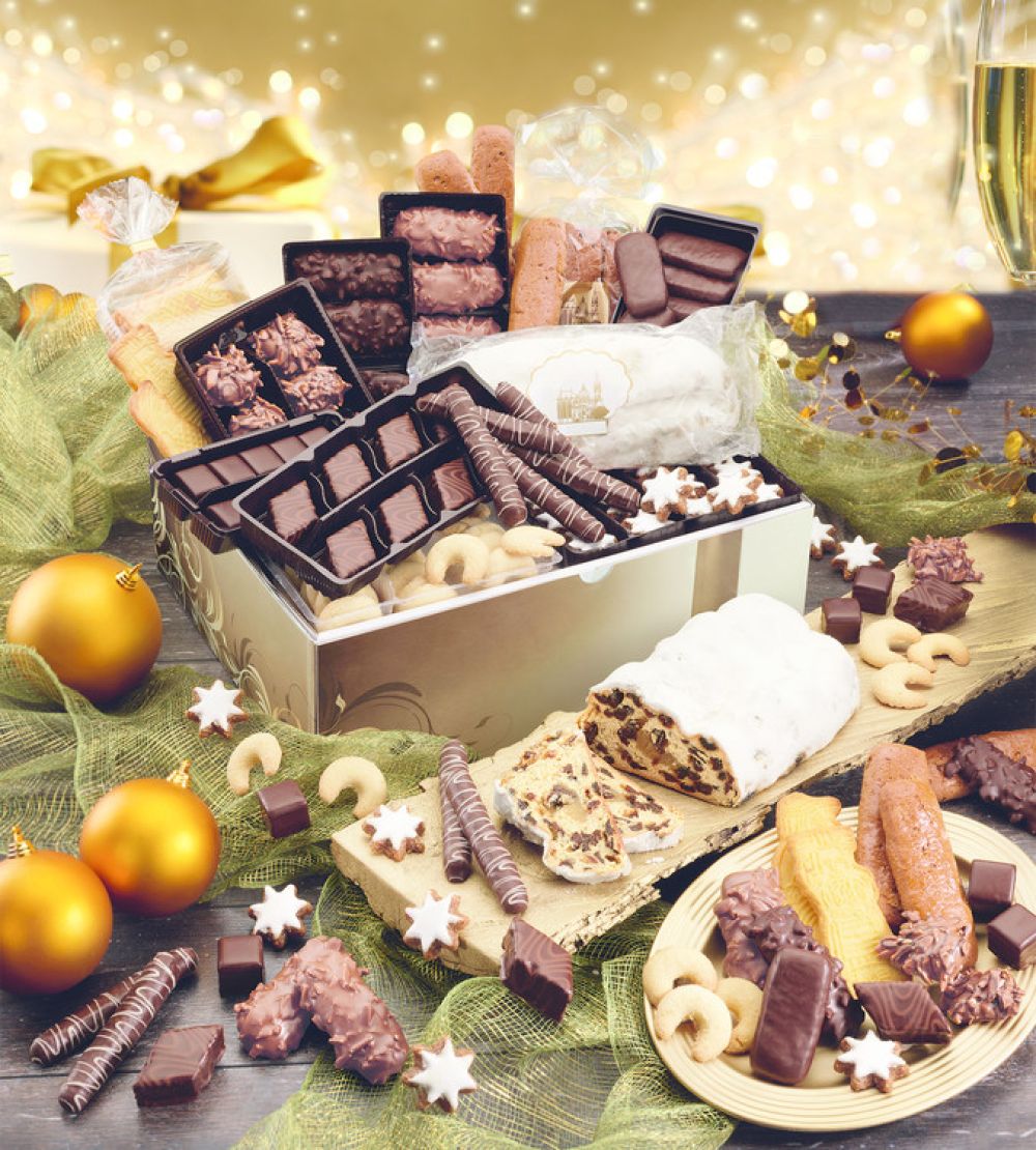 Karton gefüllt mit Stollen, Printen, Gebäck weihnachtlich dekoriert