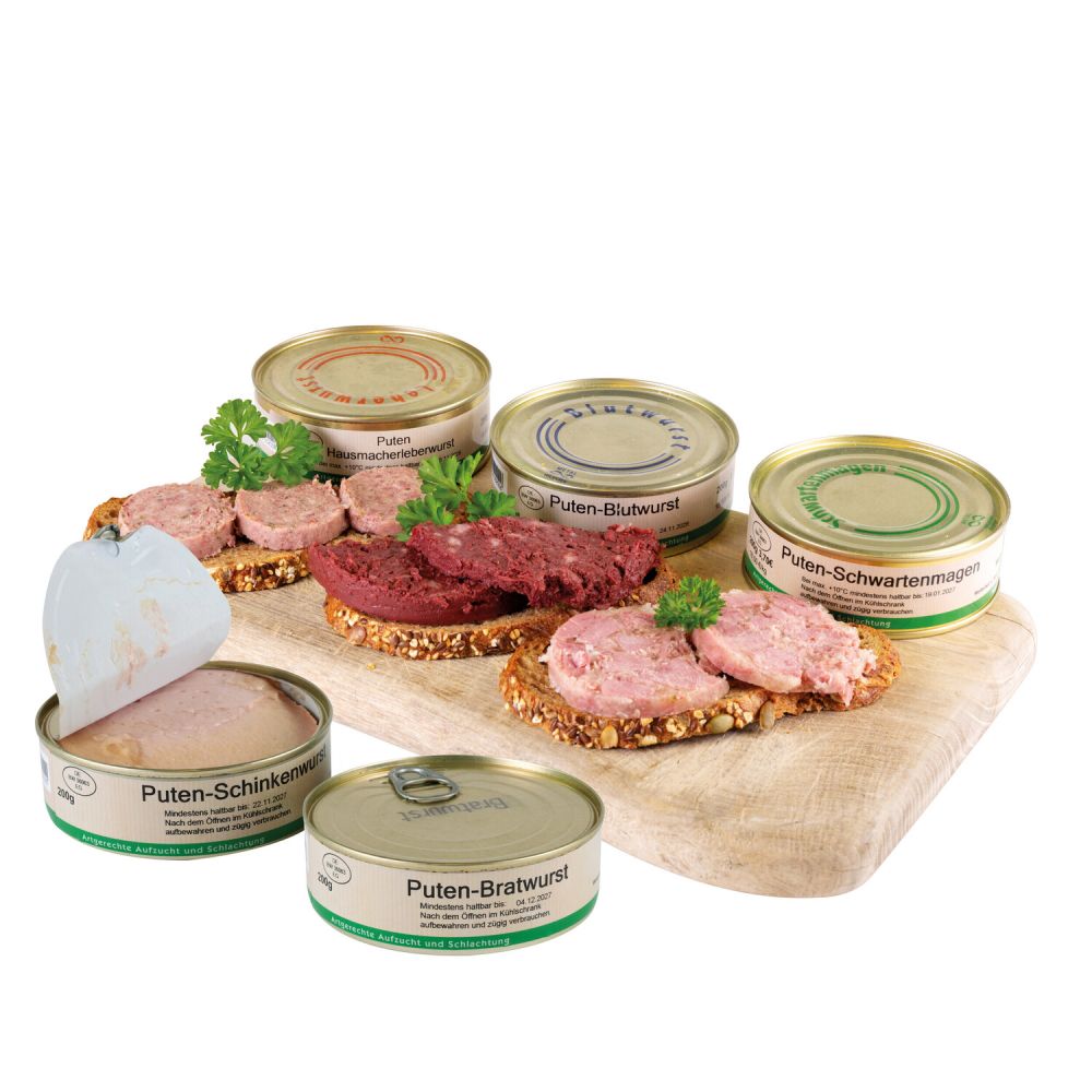 Holzbrettchen darauf 3 Wurstdosen nebeneinander, davor je eine Scheibe Brot belegt mit Wurst dekoriert mit Petersilie, vor dem Brettchen zwei einzelne Wurstdosen